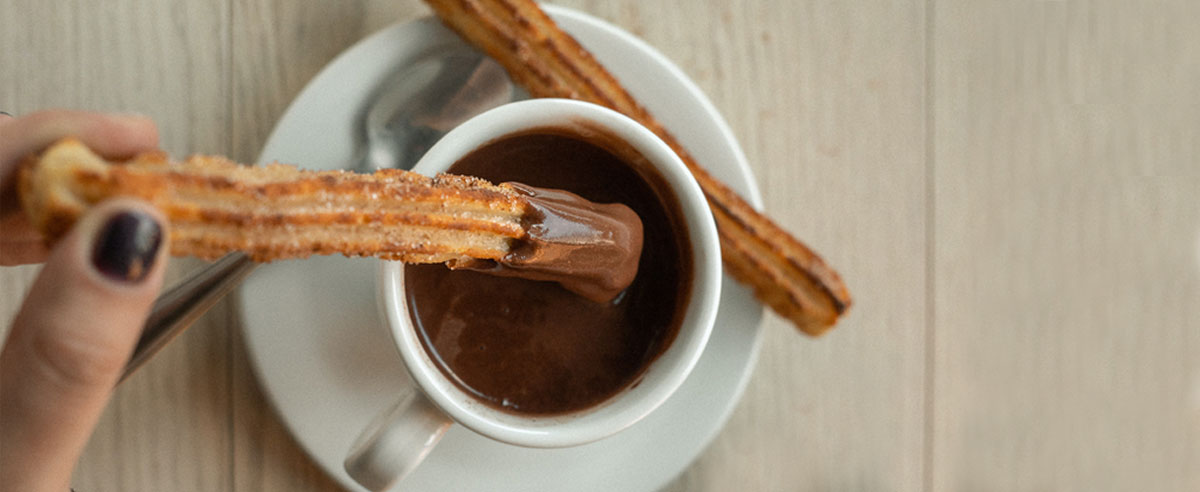 Un churros trempé dans un chocolat chaud à l'espagnole