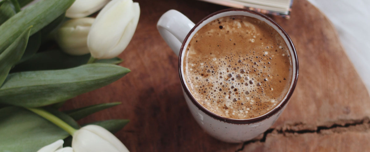 Une tasse de chocolat chaud et un bouquet de tulipes blanches