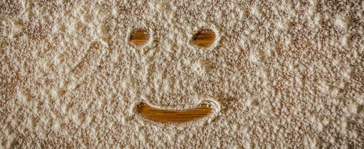 Visage souriant tracé au doigt dans de la farine de blé