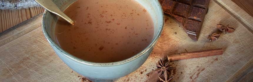 Chocolat chaud fumant parfumé aux épices chaï près d'un plaid