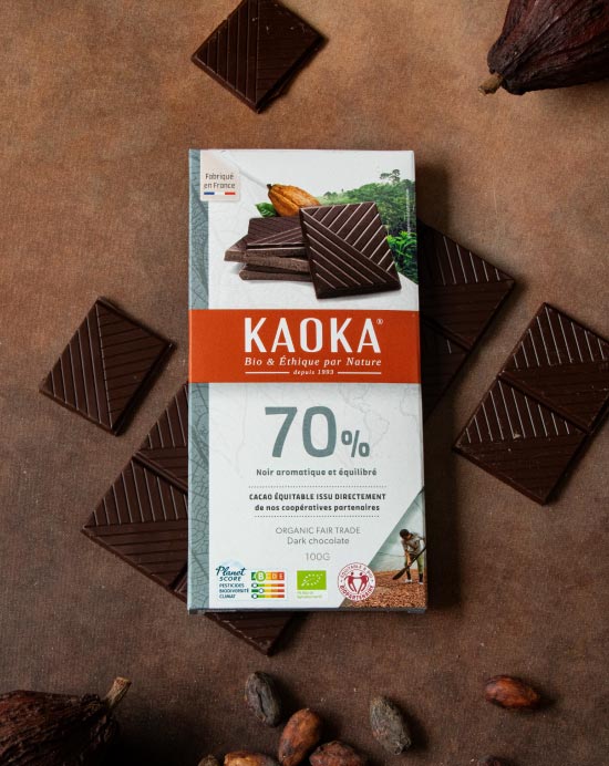 Tablette de chocolat noir 70% cacao avec des carrés de chocolat, des fèves de cacao et des cabosses séchées sur un fond marron