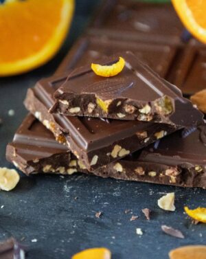 Pile de carreaux épais de chocolat noir aux écorces d'orange confite, aux amandes et noisettes caramélisées de la marque Kaoka