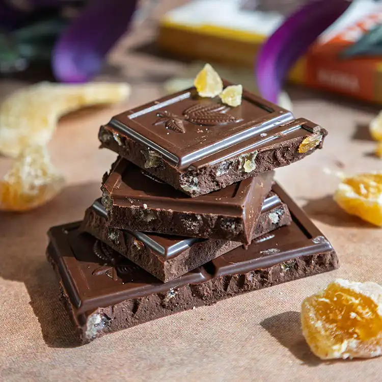 Pile d'épais carreaux de chocolat noir au gingembre confit bio et équitable de la marque Kaoka
