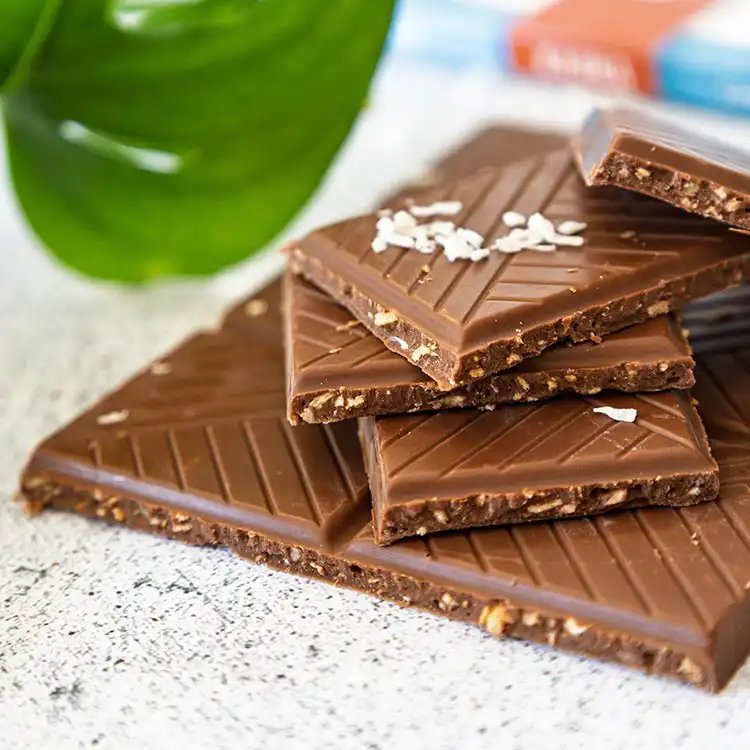 Pile de carreaux de chocolat au lait et aux copaux de noix de coco de la marque Kaoka