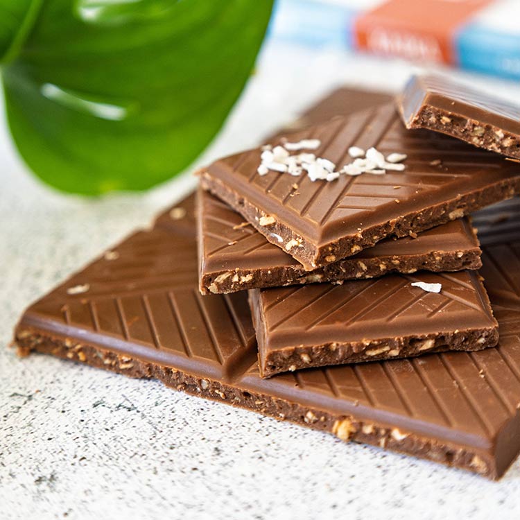 Pile de carreaux de chocolat au lait et aux copaux de noix de coco de la marque Kaoka